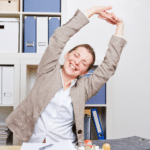 woman at a desk doing a side stretch