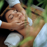 Woman getting massaged outdoors in a leafy setting