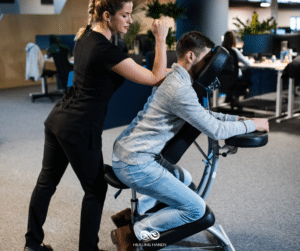 a woman giving chair massage to a seated man