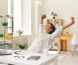 A woman stretching at her desk